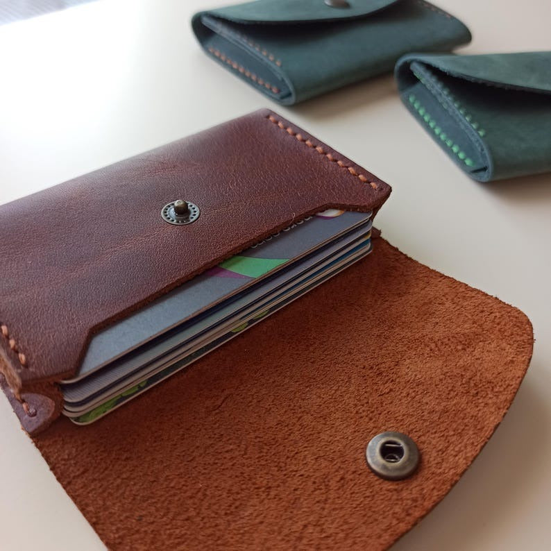 Brown leather wallet with card slots on a white surface