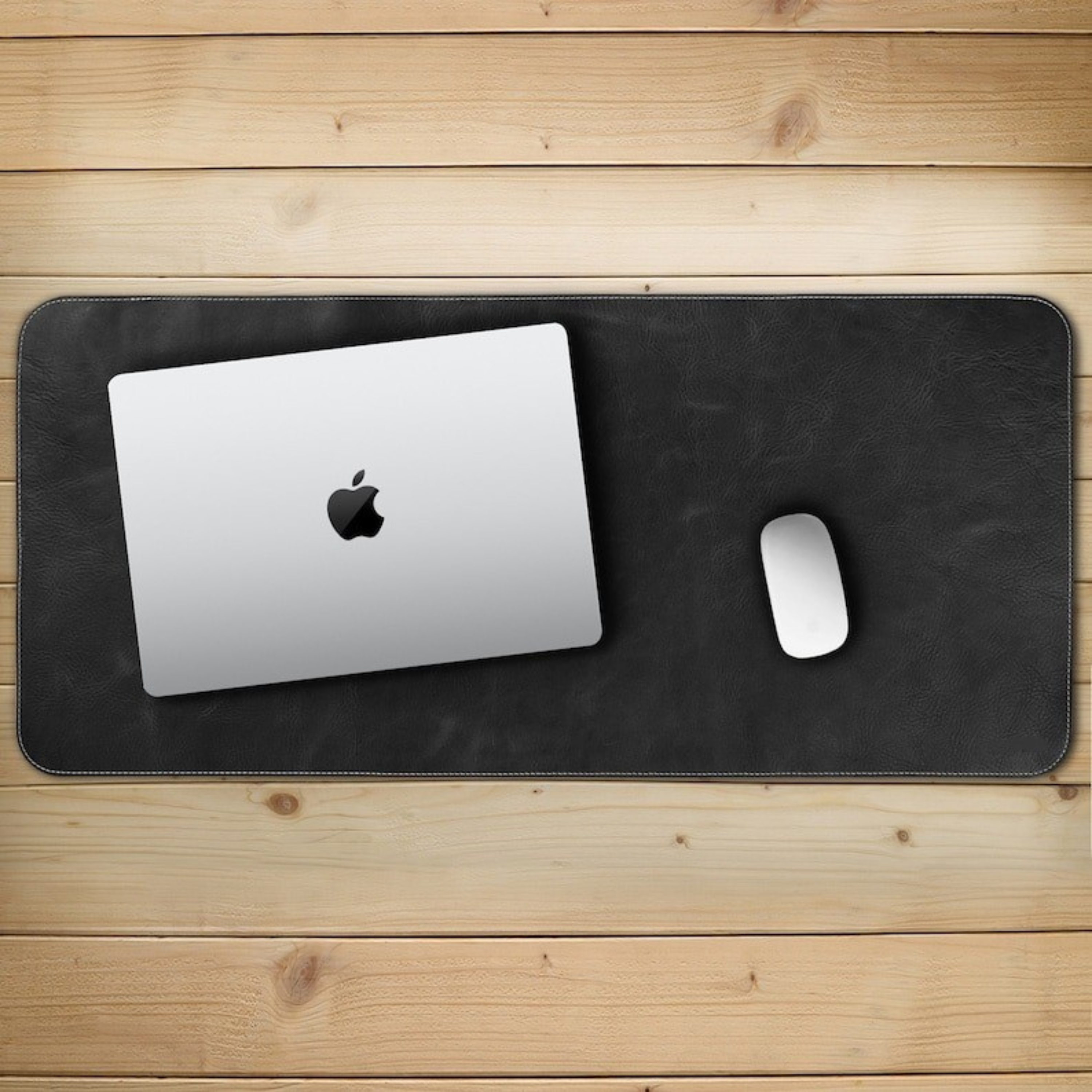 Black leather desk mat with a laptop and mouse on a wooden surface